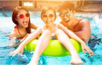 Parents holding onto kid in inner tube in pool